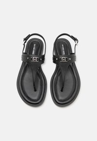 Zwarte Michael Kors sandalen met een thong ontwerp, leren bovenwerk, verstelbare enkelband en zilveren logo hardware detail.