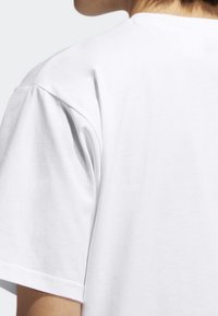 Vit t-shirt med rund halsringning och korta ärmar, med en slät och mjuk textur. Minimalistisk design utan synliga mönster eller accenter.