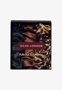 Sett med fire scrunchies i ren silke i svart, brun og leopardmønster, pakket i en svart eske med rosa og gullmerke.