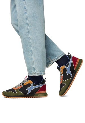 Sneaker nera e multicolore con caratteristiche in suede e mesh, dettagli a zigzag, colletto imbottito e suola in gomma testurizzata con un motivo triangolare.