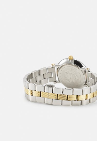 Metal watch with a silver stainless steel band featuring yellow gold accents and textured links. Round case with a gold crown.
