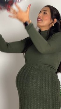 Maglione verde a coste con collo alto, vestibilità oversize e motivo testurizzato. La modella sta alzando le braccia verso l'alto.