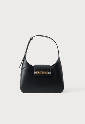 Sac bandoulière en cuir noir avec sangle réglable et logo DKNY doré sur le rabat avant, sur fond blanc.