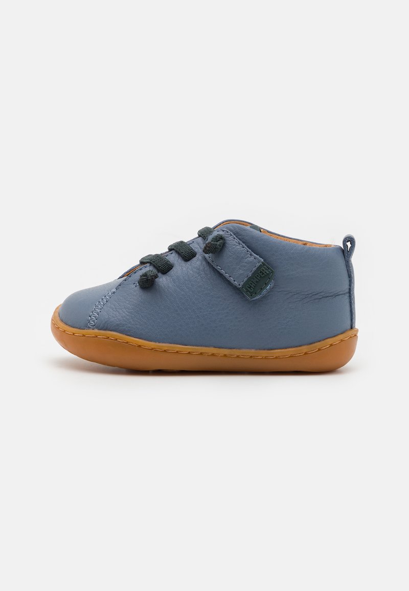 Scarpa in pelle blu con suola in gomma beige, dotata di chiusura con lacci neri, una cintura a strappo e dettagli di cucitura lungo i bordi.