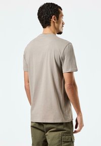 Lys beige bomull T-skjorte med rund hals og korte ermer, med et enkelt design og en rett søm.