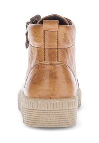 Bottine en cuir tan avec surface texturée, semelle en caoutchouc plate et fermeture à glissière à l'arrière. Des accents cousus améliorent le design.