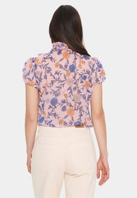 Šviesiai rožinė trumpomis rankovėmis bluzonė su oranžiniais ir mėlynais gėlėmis. Turi volanėlį apykaklėje ir lengvą audinį.