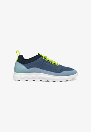 Zapatillas de malla en color marino con una parte superior texturizada, acentos en azul claro, cordones en amarillo neón y una suela blanca con un patrón de olas.