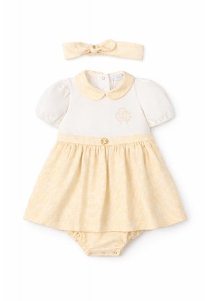 Robe bébé crème et jaune pâle avec manches bouffantes, col Claudine, bloomer assorti et bandeau avec nœud, décorée d'un motif subtil et d'un emblème.