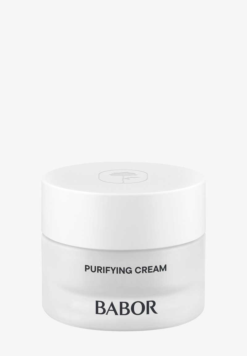 Pot rond en verre avec un corps lisse et transparent et un couvercle blanc. Le texte indique "CRÈME PURIFIANTE" et "BABOR" en lettres noires en gras.