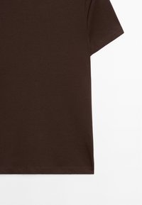 Brun kortærmet T-shirt lavet af glat bomuld, med en klassisk rund hals og lige kant med minimalt synlige syninger.