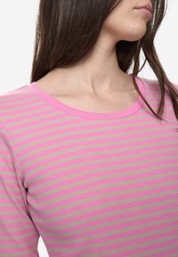 Geribde top met lange mouwen en horizontale roze en beige strepen, voorzien van een ronde halslijn en een aansluitend ontwerp.