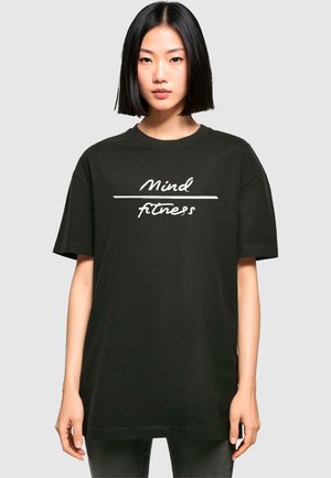 Sort bomulds t-shirt med afslappet pasform, prydet med hvid tekst "Mind fitness" trykt hen over fronten. Korte ærmer og rund halsshul.