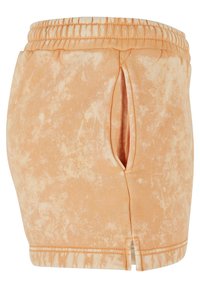 Peachfargede shorts laget av myk stoff, med et tie-dye mønster, elastisk midjebånd og sideslit for økt bevegelse og komfort.