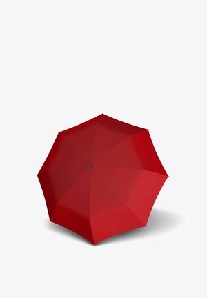 Geöffneter roter Regenschirm von oben betrachtet, der einen Schatten auf eine weiße Oberfläche wirft.