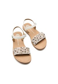 Sandalias de cuentas con una tira en rosa claro y blanco, decoradas con cuentas de diferentes tamaños. Suela plana y diseño abierto.