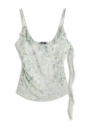 Camisole à bretelles spaghetti, floral vert clair, avec un col à volants et un détail de lien sur le côté, posé à plat sur un fond blanc.