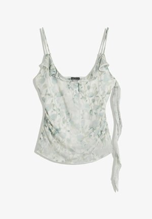 Camisola verde chiaro a fiori con spalline a spaghetto, scollatura con volant e dettaglio annodato sul lato, adagiata su uno sfondo bianco.