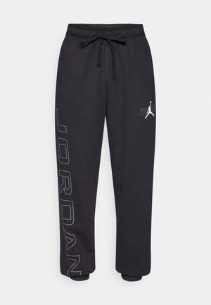 Pantaloni della tuta neri realizzati in tessuto morbido, con una vita elastica dotata di cordino, tasche laterali e un logo "JORDAN" ben visibile sulla gamba.