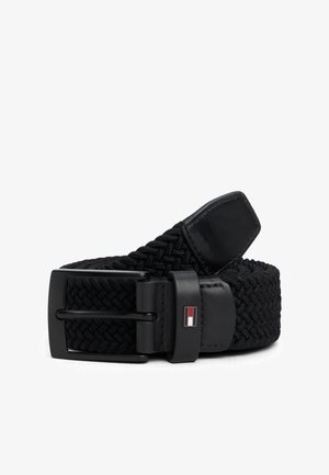 Ceinture en tissu tissé noir avec une boucle en métal noir mat, arborant un petit logo en accent. La ceinture a une finition texturée et un capuchon en cuir.