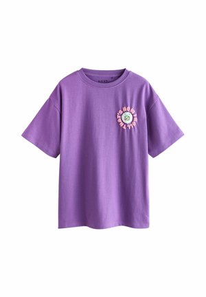 Purple cotton t-shirt with short sleeves and a round neckline. Features a circular graphic with text and a flower design on the chest.