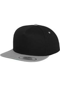 Čierna šiltovka snapback s plochým sivým šiltom. Vyrobená z textilu, má okrúlu vrchnú časť a značkovú nášivku na spodnej strane šiltu.