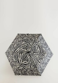 Parasol w zebrę o czarno-białym wzorze, posiadający sześciokątny kształt oraz materiałowy daszek z teksturowanymi paskami.
