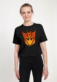 Černé tričko s velkým grafickým designem robotické tváře ve stupních přechodu od oranžové po žlutou, krátké rukávy a klasický kulatý výstřih.