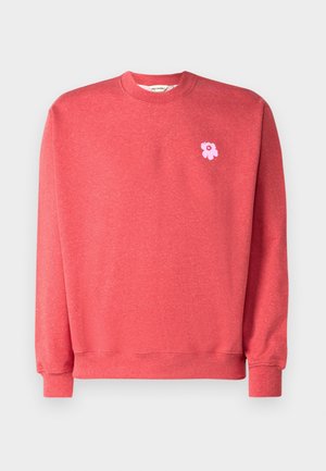 Červená crewneck mikina s textúrovanou látkou a dlhými rukávmi. Má malé výšivky ružovej kvetiny na ľavej strane hrudi.