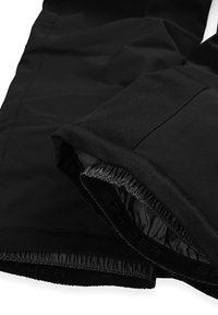 Zwarte geïsoleerde broek met een gladde buitenkant, elastische boorden en een voering met de merknaam "SPYDER." Platte naadontwerp op de stof.