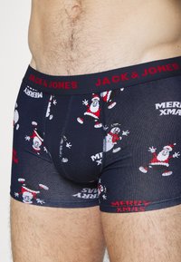 Muški pamukasti bokserice tamnoplave boje, s motivima veselih Djed Mraza i snjegovića, a s crvenom elastičnom trakom "JACK & JONES" na kojoj piše "MERRY XMAS."