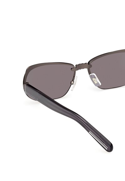 Gafas de sol negras con lentes angulares, marco de plástico resistente y almohadillas nasales transparentes. Las patillas presentan sutiles rayas blancas para un detalle adicional.