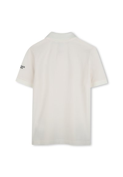 Polo shirt blanc avec un col côtelé, des manches courtes à poignets contrastés, et un logo imprimé sur la manche gauche. Tissu doux et texturé.