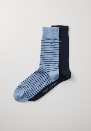 Blaue und marineblaue Socken, eine mit horizontalen Streifen, die andere einfarbig. Weicher Stoff mit dem Tommy Hilfiger-Logo, das an der Unterseite aufgedruckt ist.