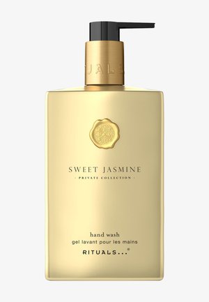 Flacon de savon pour les mains doré avec un distributeur à pompe noir. Présente un logo et un texte en relief pour "Sweet Jasmine" Collection Privée.