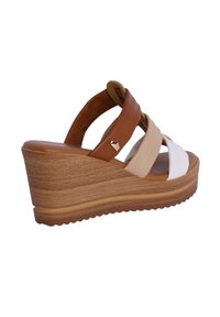 Sandalia de cuña con correas en marrón, crema y blanco. Material de cuero suave y suela con textura de madera. Acento en forma de corazón en la correa.