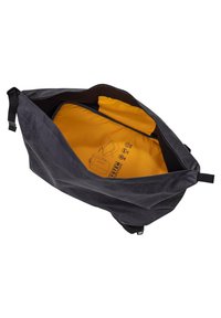 Schwarze Leinenshopping-Tasche mit einem geräumigen gelben Innenraum, ausgestattet mit einem Reißverschluss und grafischen Details zur Innenaufbewahrung.