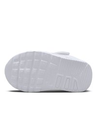 Suela de zapatilla blanca con goma texturizada y un patrón de relieve, que incluye formas geométricas y un logo de Nike estampado en el lateral.