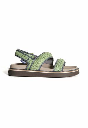 Sandal de tela tejida verde con dos correas anchas y una plantilla acolchada. Presenta una suela marrón con costuras blancas y una correa trasera ajustable.