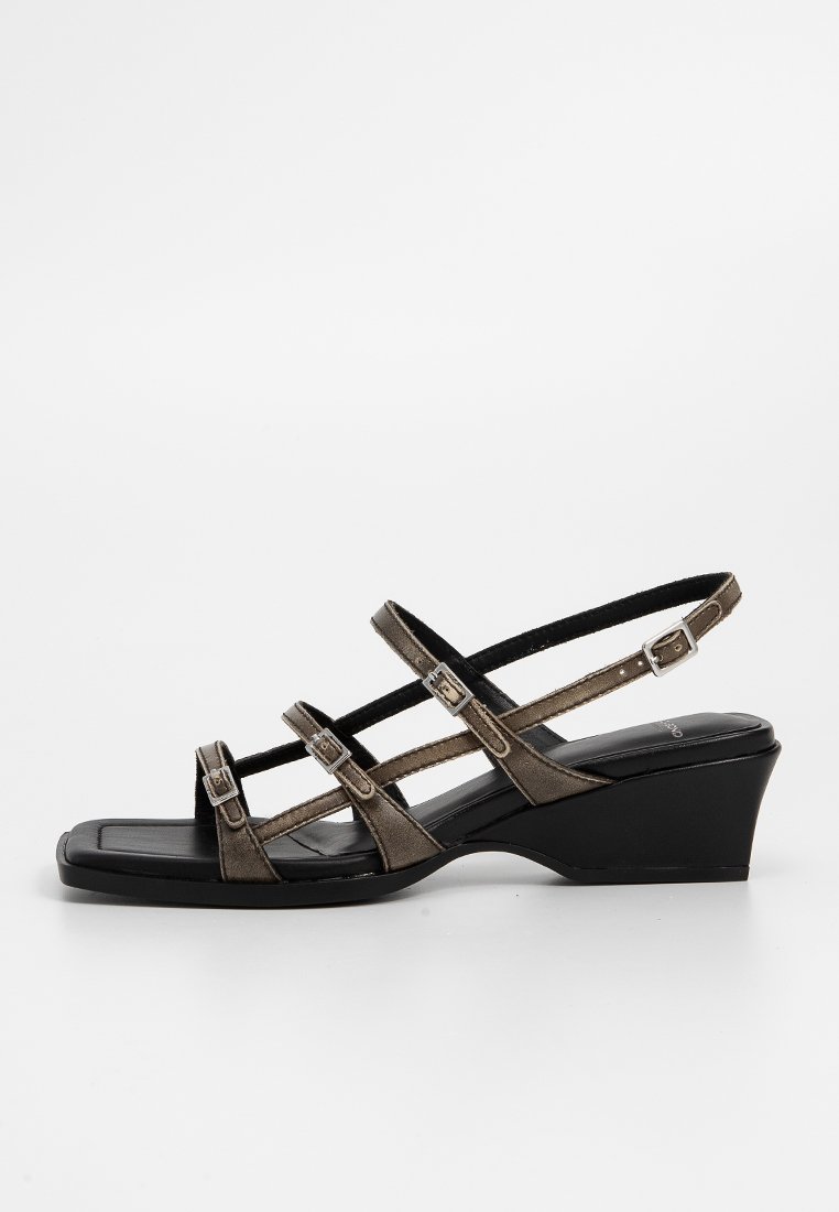 Sandales compensées en cuir marron foncé avec trois brides ajustables et bout carré. Elles disposent d'un talon compensé texturé noir.