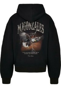 Felpa nera con cappuccio caratterizzata da una stampa grafica di un'aquila con fulmini, e il testo "M. GONZALES" in un carattere logorato sopra il design.