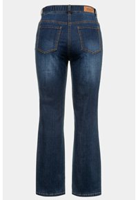 Jeans de mezclilla azul oscuro con diseño de pierna acampanada, que cuentan con una cinturilla elástica y dos bolsillos en la parte posterior. Pequeña etiqueta de cuero en la parte trasera.