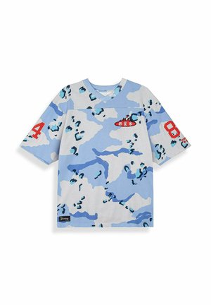 Koszulka z krótkim rękawem i dekoltem w serek, z niebiesko-białym wzorem moro, czerwonymi naszywkami z numerami na rękawach oraz małym czerwonym logo z białymi znakami na piersi.