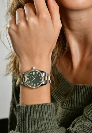 Analog watch with a dark green face, gold and silver metal band, diamond-like accents on the bezel, and large numerals for easy reading.