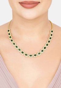 Gold-tone necklace featuring emerald-cut green gemstones set in rectangular frames, with a braided chain design.