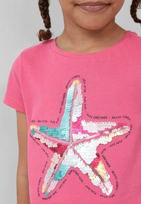 Roze katoenen T-shirt met een kleurrijk sterfiszontwerp van glanzende pailletten, omringd door de tekst "zonnedromer" en "strand vibes".