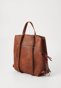 Ruskea tekonahkainen reppu, jossa on kaksi yläkahvaa, säädettävät olkahihnat, etuosassa vetoketjullinen tasku ja sivuakkenttikohteet.