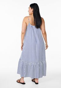 Gestreiftes Maxikleid mit blauen und weißen vertikalen Streifen, Spaghetti-Trägern und einem Rüschensaum. Hergestellt aus leichtem Stoff mit lockerer Passform.