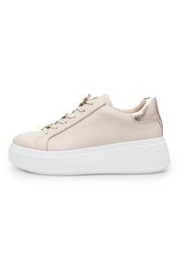 Sneaker in pelle beige con dettagli metallici, punta rotonda e suola piatta bianca. Caratterizzato da lacci decorativi e una texture liscia.