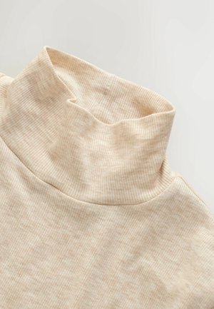 Beige ribbet turtleneck top med en blød struktur, der har en høj krave og tætsiddende silhuet, hvilket understreger enkelhed i designet.